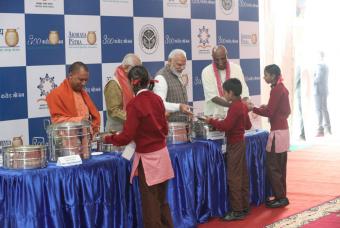 From left to right, Shri Yogi Adityanath, Shri Ram Naik, Shri Narendra Modi and Shri Madhu Pandit Dasa, serve hot nutritious Akshaya Patra food to the children