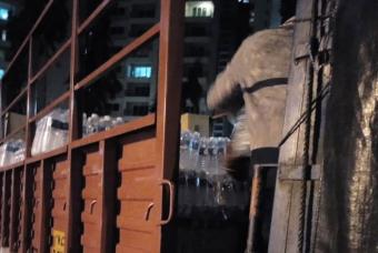 Trucks being loaded with food and water bottles 