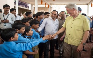 An excited bunch of kids shakes hands with US Ex-President. Photo credit: Clinton Foundation/ Barbara Kinney