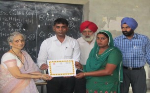 Haryana cook cum helper being appreciated with a certificate for being part of the Phase III training programme